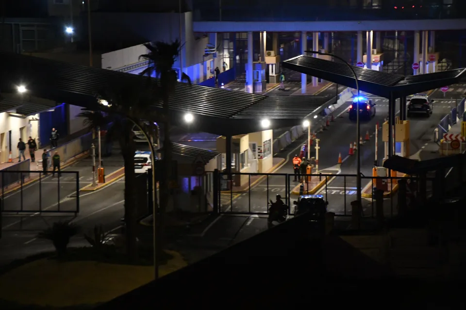 Paso fronterizo del Tarajal en Ceuta durante la noche, con presencia policial y controles de seguridad.